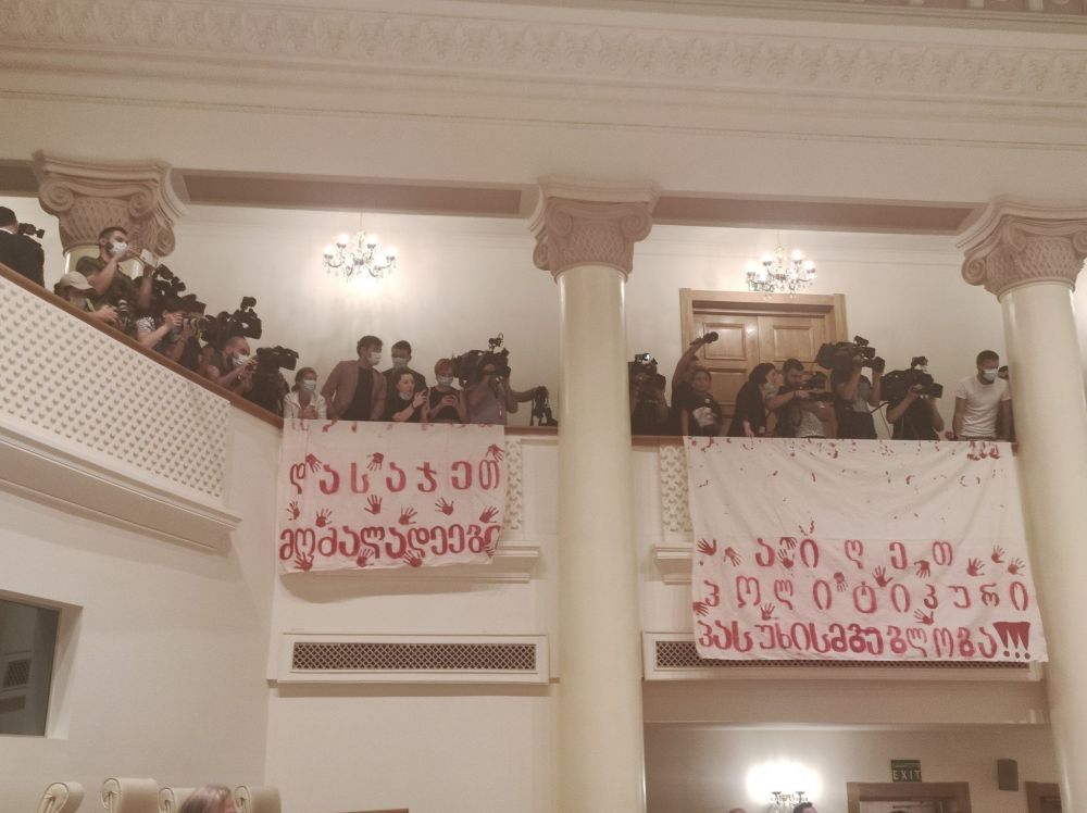 პარლამენტში ვახტანგ გომელაურს პლაკატებით დახვდნენ, რასაც სხდომის ჩაშლა მოყვა